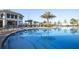 Community clubhouse with a pool surrounded by lounge chairs and palm trees at 3150 Paradox Cir # 104, Kissimmee, FL 34746