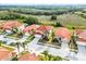Wide aerial view of the neighborhood featuring homes with red tile roofs, mature trees, and pristine landscaping at 321 Rosso Dr, Davenport, FL 33837