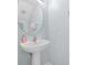 Close-up of bathroom pedestal sink with round mirror and wall-mounted towel rack at 321 Rosso Dr, Davenport, FL 33837