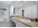 Well-lit bathroom features a soaking tub, vanity with sink, and framed mirrors at 321 Rosso Dr, Davenport, FL 33837