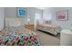 Bright bedroom featuring two twin beds with colorful chevron comforters, and a nightstand at 321 Rosso Dr, Davenport, FL 33837