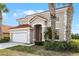 A two-story house has a neutral color scheme, two palm trees, a red tile roof, and a two-car garage at 321 Rosso Dr, Davenport, FL 33837