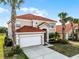Beautiful two-story home with a red tile roof, lush landscaping, and a two-car garage at 321 Rosso Dr, Davenport, FL 33837