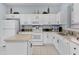 The kitchen features white cabinetry, stone backsplash, matching appliances, and an island at 321 Rosso Dr, Davenport, FL 33837
