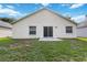Home's backyard featuring a grassy lawn, patio and sliding glass door at 3370 Cypress Point Cir, St Cloud, FL 34772