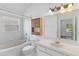Well-lit bathroom with tub, tiled walls, and a vanity sink with storage at 3370 Cypress Point Cir, St Cloud, FL 34772