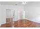 Bedroom featuring hardwood floors, a ceiling fan, mirrored closet doors, and neutral walls at 3370 Cypress Point Cir, St Cloud, FL 34772