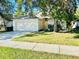 Inviting single-story home featuring a two-car garage and lush landscaping at 3370 Cypress Point Cir, St Cloud, FL 34772