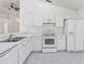Bright kitchen featuring white cabinetry, appliances, laminate countertops, and tile flooring at 3370 Cypress Point Cir, St Cloud, FL 34772