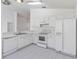 Bright kitchen with white cabinetry, appliances, tile floors, and laminate countertops at 3370 Cypress Point Cir, St Cloud, FL 34772