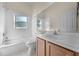 Bathroom featuring a vanity with a sink and a tub with white tiled surround and a window at 3893 Blackberry Cir, St Cloud, FL 34769