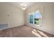 Formal dining room offering neutral carpeting, a modern chandelier, and views of the landscaped front yard at 3893 Blackberry Cir, St Cloud, FL 34769