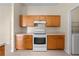 Kitchen with matching wood cabinetry and white appliances at 3893 Blackberry Cir, St Cloud, FL 34769