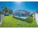 Lush green backyard featuring a screened-in pool with ample space for entertaining and relaxation at 3893 Blackberry Cir, St Cloud, FL 34769