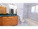 Bathroom with a tiled shower-tub combo, vanity with green countertop, and wood cabinets at 408 Sandpiper Ridge Dr, Orlando, FL 32835