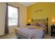 Comfortable bedroom with decorative yellow walls, patterned bedding, and natural lighting at 426 Prestwick Dr, Davenport, FL 33897