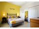 Comfortable bedroom with decorative yellow walls, patterned bedding, and neutral accents at 426 Prestwick Dr, Davenport, FL 33897