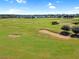 Scenic view of the lush green golf course with sand traps and mature trees in the Highlands Reserve Community at 426 Prestwick Dr, Davenport, FL 33897