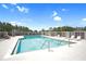 Community pool with crystal clear water, lounge chairs, picnic tables, and a safety fence at 426 Prestwick Dr, Davenport, FL 33897
