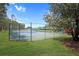 A well-maintained, fenced-in tennis court is surrounded by lush greenery in this community at 426 Prestwick Dr, Davenport, FL 33897