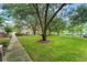Beautifully maintained front lawn of a condo building, featuring mature trees and landscaping at 438 Water St # 438, Celebration, FL 34747