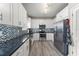 Bright kitchen with white cabinetry, stainless steel appliances, and a mosaic backsplash is stylish and efficient at 438 Water St # 438, Celebration, FL 34747
