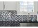 Close up of kitchen sink with subway tile backsplash and granite counters at 438 Water St # 438, Celebration, FL 34747