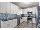 Well-lit kitchen showcases white cabinets, stainless steel appliances, granite counters, and a mosaic backsplash at 438 Water St # 438, Celebration, FL 34747