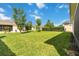 Lush backyard features an expanse of green grass, trees, and a tidy perimeter of hedges at 5009 E Fountainwood Dr, St Cloud, FL 34772