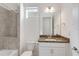 Bathroom with granite countertop vanity, framed mirror, and tiled shower and bathtub combination at 5009 E Fountainwood Dr, St Cloud, FL 34772