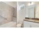 Well-lit bathroom featuring a tiled shower/bathtub combination and a granite countertop vanity at 5009 E Fountainwood Dr, St Cloud, FL 34772