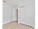 Bedroom with wood-look flooring and a closet with white sliding doors plus another closet/doorway visible at 5009 E Fountainwood Dr, St Cloud, FL 34772