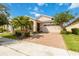 Inviting single-story home with a brick-paved driveway, two-car garage, manicured lawn, and mature landscaping at 5009 E Fountainwood Dr, St Cloud, FL 34772