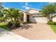 Inviting single-story home with a brick-paved driveway, two-car garage, manicured lawn, and mature landscaping at 5009 E Fountainwood Dr, St Cloud, FL 34772