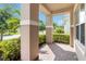 Inviting front porch with brick pavers and stately columns overlooking lush greenery at 5009 E Fountainwood Dr, St Cloud, FL 34772