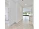 Hallway with tile flooring, neutral paint, and view to kitchen/living area with sliding glass doors at 5009 E Fountainwood Dr, St Cloud, FL 34772