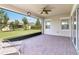 A covered patio with brick flooring and a fan offers views of the green backyard at 5009 E Fountainwood Dr, St Cloud, FL 34772