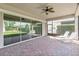 A covered patio with brick flooring and a fan offers views of the green backyard at 5009 E Fountainwood Dr, St Cloud, FL 34772