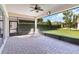 A covered patio with brick flooring and a fan offers views of the green backyard at 5009 E Fountainwood Dr, St Cloud, FL 34772