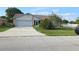 Single story home with a 2-car garage, stone accents, green grass and mature landscaping at 501 Kilimanjaro Dr, Kissimmee, FL 34758