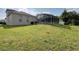 View of backyard with enclosed pool and lush green lawn under a partly cloudy sky at 518 Brighton Dr, Davenport, FL 33897
