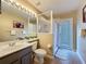 This bathroom features a tile floor, single vanity with shower and tub with glass doors and bright lighting at 518 Brighton Dr, Davenport, FL 33897