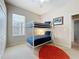 This bedroom has carpeted floors, a ceiling fan, bunk beds, closet and a window with blinds at 518 Brighton Dr, Davenport, FL 33897