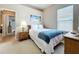 This carpeted bedroom includes a double bed, a ceiling fan, one night table and a painting on the wall at 518 Brighton Dr, Davenport, FL 33897