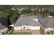 Aerial view of home with brick driveway, mature landscaping and lush, green surroundings at 518 Brighton Dr, Davenport, FL 33897