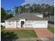 Charming single-story home with a well-manicured lawn and a brick-paved driveway leading to an attached garage at 518 Brighton Dr, Davenport, FL 33897