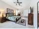 This bedroom has a ceiling fan, carpeted floors, a large bed with two matching bedside tables and lamps at 518 Brighton Dr, Davenport, FL 33897