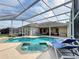 Screened-in pool and spa offer a private oasis with lounge seating and covered patio, perfect for entertaining at 518 Brighton Dr, Davenport, FL 33897
