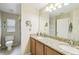 Bright bathroom featuring double sink vanity with granite, glass shower, and ample storage at 608 Grand Canal Dr, Poinciana, FL 34759