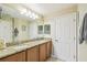 Bathroom featuring double sinks with granite countertops, a large mirror, and modern lighting at 608 Grand Canal Dr, Poinciana, FL 34759